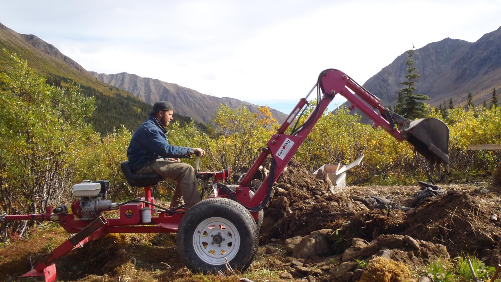 Candig mini excavator at work in the Yukon Candig mini excavator at work digging a trench for sampling
