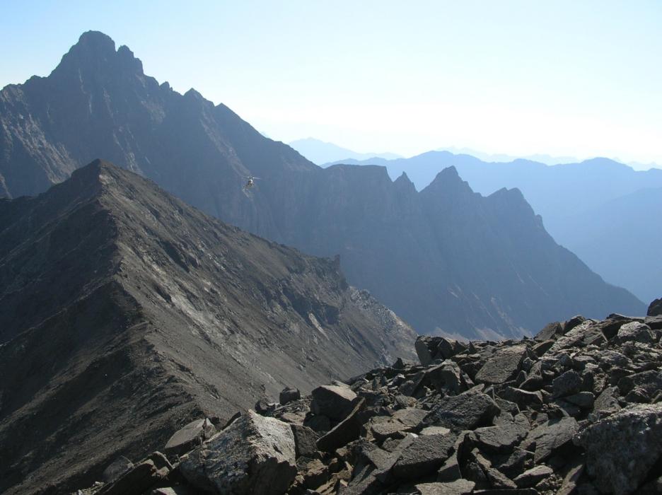 Incoming helicopter - looking north at Butress Peak from ridge between REE Yippie and REE Base-Metal anomalies at the Ice River Complex Project