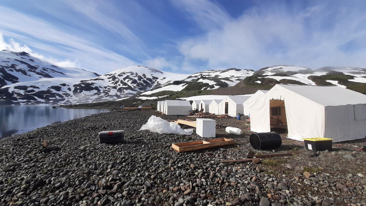 Wall tent exploration camp Exploration camp of wall tents with lake and snowy mountains in background