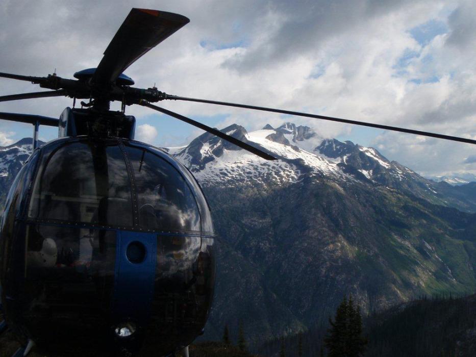 Hughs 500 helicopter and mountains Hughs 500 helicopter standing by in mountain landscape of southeast BC
