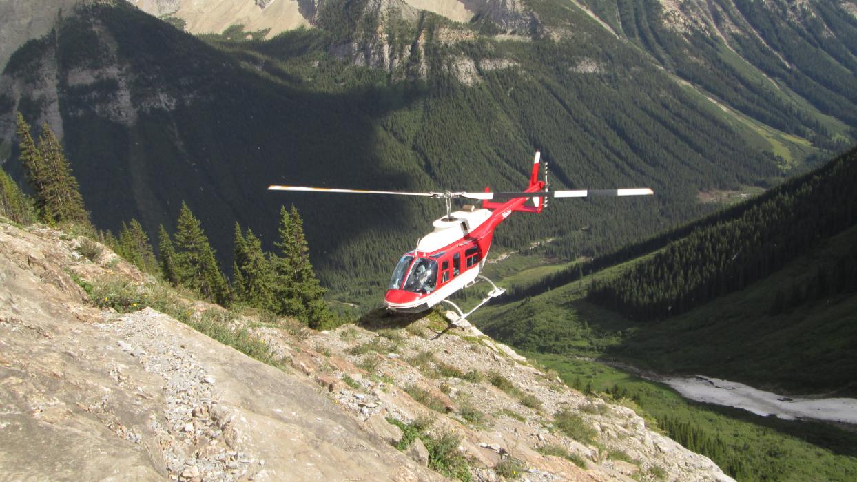 Helicopter toed in at Ice River Complex A helicopter toed in on a steep slope at the Ice River Complex in SE BC
